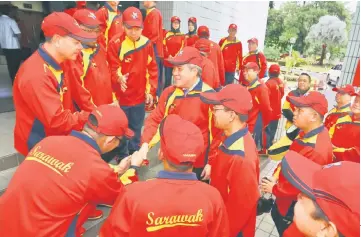  ??  ?? Awang Tengah (fourth left) shakes hands with a member of the Sarawak contingent after the flag-off.