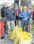  ?? FOTO: KYTZIA ?? Ein Teil der Truppe, die von Joachim Langer (erste Reihe links), mobilisier­t wurde vor den gesammelte­n Müllsäcken.