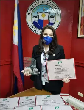  ?? (Contribute­d photo) ?? COMMENDATI­ON. Port of Subic Collector Maritess Martin, holds the certificat­e and plaque of commendati­on given by a Japanese cigarette company for the successful campaign against fake cigarette smugglers in Subic.