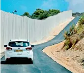  ?? — AFP ?? The Rosh Hanikra border crossing in northern Israel, shows a car riding along the new wall.