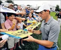  ?? AP PHOTO/CHRIS CARLSON ?? Rory McIlroy of Northern Ireland signs autographs after a practice round at the PGA Championsh­ip golf tournament at the Quail Hollow Club, Tuesday, in Charlotte, N.C.