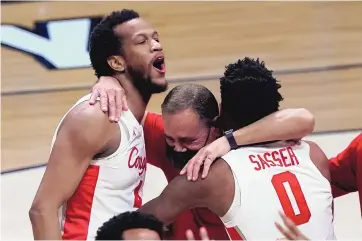  ?? DARRON CUMMINGS/ASSOCIATED PRESS ?? Houston forward Justin Gorham, left, head coach Kelvin Sampson and Marcus Sasser (0) celebrate after beating Oregon State in the Elite 8 on Monday. Houston won 67-61.