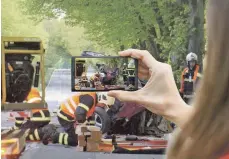  ?? FOTO: CHRISTIAN PÖRSCHMANN ?? Feuerwehrl­eute sichern die Spuren an einem Autowrack. Immer häufiger filmen Gaffer Unfälle.