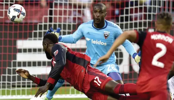  ?? FRANK GUNN/THE CANADIAN PRESS ?? Toronto FC’s Jozy Altidore heads the ball away from D.C. United goalkeeper Bill Hamid — but not in, though he did score later — in the first half of Saturday night’s match at BMO Field.