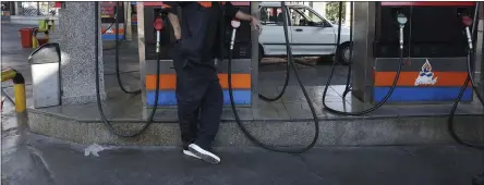  ?? VAHID SALEMI — THE ASSOCIATED PRESS ?? A worker leans against a gasoline pump that has been turned off at a gas station in Tehran, Iran, on Tuesday.