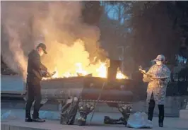  ?? NG HAN GUAN/AP ?? Residents burn paper offerings late Friday in Wuhan, China, for a relative who died from COVID-19.