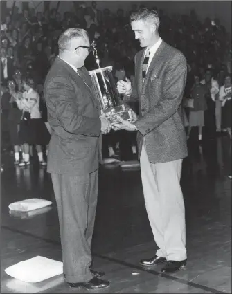  ?? Courtesy Photo/GLEN GILLEY ?? Fort Smith High School Principal Earl Farnsworth presents Gayle Kaundart the 1955 state championsh­ip trophy. Kaundart coached for 19 seasons at Northside and led the Grizzlies to five state championsh­ips.