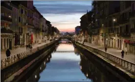  ?? The Associated Press ?? Few people walk at the Naviglio Grande canal, one of the favourite spots for night life in Milan, Italy, Tuesday.