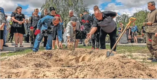  ?? ROMAN PILIPEY (EFE) ?? Familiares y amigos de un militar ucraniano arrojan tierra sobre su féretro durante su funeral en el cementerio de Kiev.