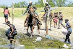  ?? —AFP ?? CAUGHT US Border Patrol agents intercept migrants carrying food along the Rio Grande on Sept. 19.