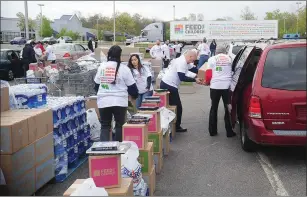  ?? Photos by Ernest A. Brown ?? Above, volunteers outside the Woonsocket PriceRite help distribute food and essentials to 800 local families in need as PriceRite partnered with Feed the Children, Conagra and Connecting for Children and Families for Tuesday’s charitable endeavor....