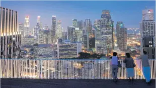  ??  ?? Residents of the Duxton public housing estate in Singapore gaze at the skyline.