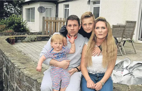  ??  ?? A family man’s life in tatters: Philip Moreton with partner Cheyrell Davie and their children Lennon and Karsen at home in Glen Prosen.