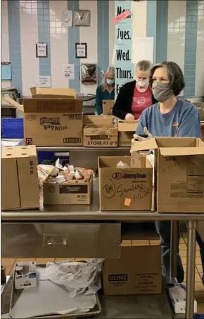  ?? PHOTO COURTESY OF NORTH PENN SCHOOL DISTRICT ?? North Penn School Nutrition Services staff wear masks and maintain safe distancing while preparing meals at a central kitchen to be given away to students in need.