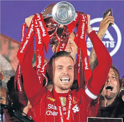  ??  ?? Liverpool skipper Jordan Henderson lifts the Premier League trophy.