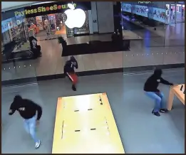  ?? SANTA ROSA (CALIFORNIA) POLICE ?? Security footage shows thieves rushing into a San Francisco Bay Area Apple store and grabbing devices on display while staff and customers looked on.