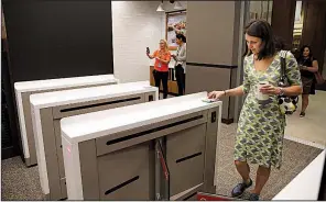  ?? Chicago Tribune/STACEY WESCOTT ?? Irena Kubiliene scans her phone as she enters the new Amazon Go store on South Franklin Street in Chicago in September.