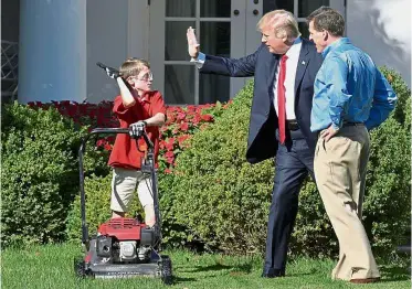  ?? — AFP ?? Hello there: Trump high-fiving FX as he mows the lawn in the Rose Garden of the White House in Washington, DC.