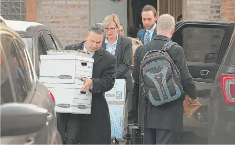  ?? SCOTT OLSON/GETTY IMAGES ?? People believed to be federal agents remove equipment and boxes from the South Side office of Ald. Ed Burke on Thursday.