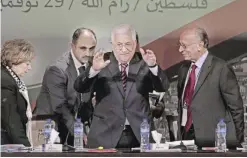  ??  ?? RAMALLAH: Palestinia­n President Mahmoud Abbas, center, waves to fellow Fatah members as he arrives for the opening session of the Fatah party conference, in the West Bank city. — AP