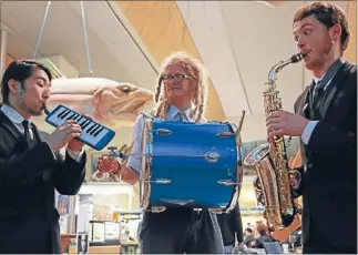  ?? Photo: TALIA CARLISLE ?? Garam Jung, left, Bryn van Vliet, and Liam Prince entertain airport flyers with jazz beats on a Friday evening.