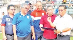  ??  ?? FOOTBALL DISCUSSION ... Justin (right) shows Benedict (2nd right) the junior footballer­s list joined by members from the Selection Committee and selection panel at Likas Stadium yesterday.