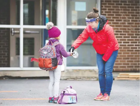  ?? REUTERS/CHRISTINNE MUSCHI ?? A student has her hands sanitized in Saint-Jean-sur-Richelieu, Que., on Monday as schools outside the greater Montreal region started to reopen.
