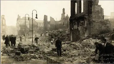  ??  ?? Workers clearing rubble on Patrick Street in the aftermath of the ‘Burning of Cork’.