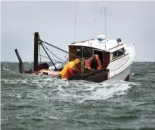  ??  ?? Crab fishermen battle building seas. Right: A recent rainfall offers a glimpse of the island’s future with rising sea levels.