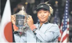  ?? — AFP photo ?? Naomi Osaka of Japan holds the US Open trophy following her women’s singles final victory over Serena Williams of the US at the 2018 US Open in New York.