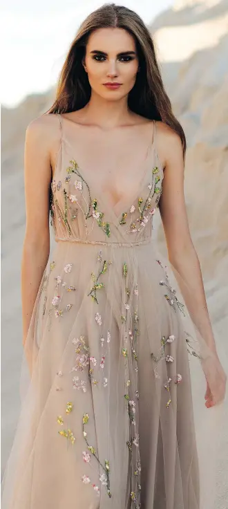  ?? ETSY ?? Embellishm­ents like beads, silky threads and sequins on this silk, chiffon and tulle gown by Maria Kolomoiets are a big bridal trend. Designers are even offering dresses in blush, navy, celadon, peach and ombre hues.