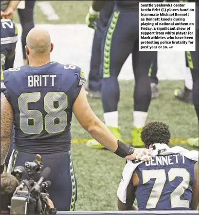  ?? AP ?? Seattle Seahawks center Justin Britt (l.) places hand on teammate Michael Bennett as Bennett kneels during playing of national anthem on Friday, a significan­t show of support from white player for black athletes who have been protesting police...