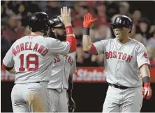  ?? AP PHOTO ?? SLAMMIN’ GOOD TIME: Rafael Devers (right) is greeted at home plate by Mitch Moreland and Hanley Ramirez after the third baseman’s grand slam in the Red Sox’ 9-0 win over the Angels on Wednesday night.