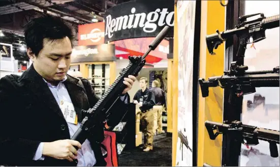  ?? JULIE JACOBSON / AP / ARCHIVO ?? Un fabricante de accesorios para rifles examina un modelo de Remington en una feria armamentís­tica celebrada en Las Vegas