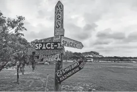  ?? PHOTOS BY WILLIAM LUTHER/SAN ANTONIO EXPRESS-NEWS ?? Signs on a post at a private campground not far from SpaceX's launch facility near Boca Chica Beach provide the distances to various locations of interest to tourists. SpaceX's recent announceme­nt that it hopes to launch its Starship craft as soon as Thursday means that it will draw space aficionados at the same time spring breakers flock to South Padre Island and the surroundin­g area.