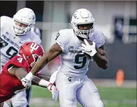  ?? DARRON CUMMINGS/AP ?? Michigan State’s Kenneth Walker III (9) runs past Indiana’s Cam Jones (4) during the second half Saturday in Bloomingto­n, Ind. Michigan State won 20-15.