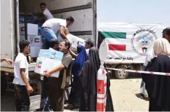  ??  ?? MOSUL: Kuwaiti aid workers deliver food aid to people in the eastern district of the Iraqi city of Mosul. — KUNA Photos
