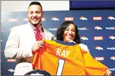  ??  ?? Shane Ray (left), the Missouri pass rusher selected by Denver Broncos in the first round of the NFL Draft, holds his team jersey with his mother Sebrina
Johnson after a news conference on May 1 in Englewood, Colorado. (AP)