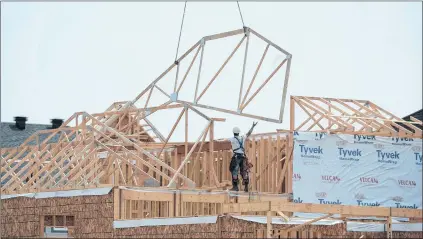  ?? CP FILE ?? Constructi­on workers build new homes in a developmen­t in Ottawa in July 2015. Experts say lender risk sharing might make banks more cautious.