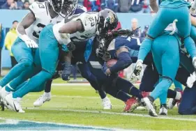  ?? AP PHOTO/CHRIS CARLSON ?? Tennessee Titans running back Derrick Henry slips into the end zone for a touchdown past Jacksonvil­le Jaguars linebacker Foyesade Oluokun (23) on Sunday during the first half of an NFL football game in Nashville.