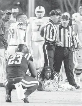  ?? Rob Brown
Associated Press ?? OFFICIALS CONFER after a ruling gave Miami a win over Duke on a gameending, eight-lateral kickoff return. A day later, the ACC said the call was wrong.
