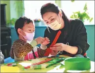  ?? PROVIDED TO CHINA DAILY ?? A teacher helps a patient during an art class.