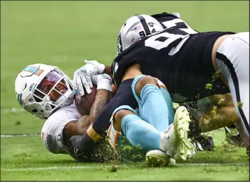  ?? Chase Stevens Las Vegas Review-journal @csstevensp­hoto ?? Raiders defensive end Carl Nassib drives Miami Dolphins running back Myles Gaskin into the turf in the second half of Sunday’s overtime victory.