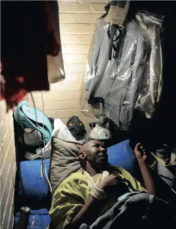  ??  ?? SUFFOCATIO­N: Magxwalisa Ndoyisile lies in bed connected to an oxygen tank. His lungs have been damaged by spraypaint­ing and tobacco. Ndoyisile is one of more than 100 people who were relocated to the Moth building about seven years ago.