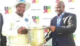  ??  ?? Mountainee­rs captain Tino Mawoyo (left) holds the Logan Cup silverware with Zimbabwe Cricket chairman Tavengwa Mukhuhkani