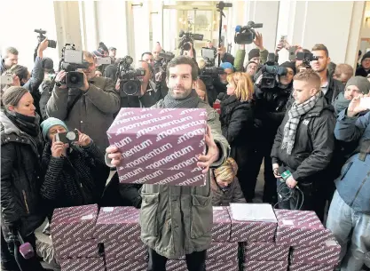  ??  ?? Momentum Movement leader Andras Fekete-Gyor with the collected signatures of Budapest residents against the country’s bid to host the 2024 Olympics.