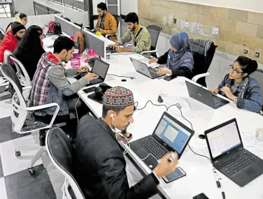  ?? ?? CUSTOMER SUPPORT Employees of Taza Transformi­ng Agricultur­e talk with customers at a call center in Lahore. Until recently, ‘the most modern machine we had was the tractor,’ said Aamer Hayat Bhandara, a farmer and local councilor in Punjab province. Even making mobile phone calls can be difficult in many parts of Pakistan, farmers have been given free access to the internet— and it is revolution­izing the way they work.