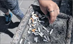  ?? CP PHOTO ?? The Supreme Court of Canada says British Columbia does not have to give a tobacco company access to detailed provincial health databases to ensure the fairness of a multibilli­on-dollar damages trial. A smoker puts out a cigarette in a public ashtray in...