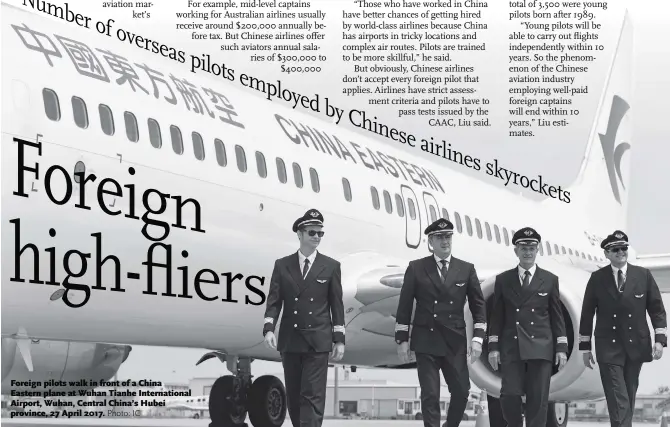  ??  ?? Foreign pilots walk in front of a China Eastern plane at Wuhan Tianhe Internatio­nal Airport, Wuhan, Central China’s Hubei province, 27 April 2017.