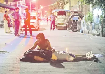  ?? — AFP photo ?? File photo shows Nanette Castillo grieving over the dead body of her son Aldrin, an alleged drug user killed by unidentifi­ed assailants, in Manila.